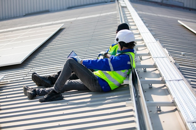 Profesjonalny pracownik instalujący panele słoneczne na dachu domu