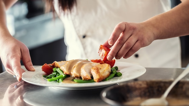 Profesjonalny szef kuchni w restauracji przygotowuje zamówienie na jedzenie