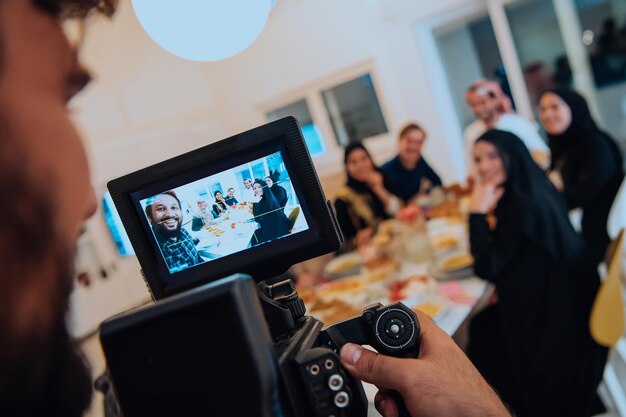 Profesjonalny wideograf nagrywający wideo, podczas gdy muzułmańska rodzina spożywa razem iftar podczas Ramadanu.