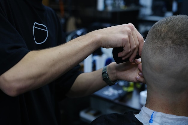 Professional Master barber goli brodę klienta elektrycznym trymerem Strzyżenie męskiej brody w salonie fryzjerskim Barber Men Koncepcja reklamy i salonu fryzjerskiego