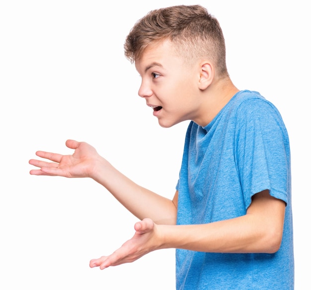Profil krzyczącego chłopca emocjonalny portret irytowanego białego nastolatka Wściekły nastolatek krzyczący i patrzący z gniewem na bok Ładne oburzone dziecko krzyczące głośno na białym tle