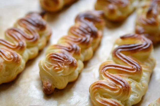 Profiteroles lub eklery bez kremu na blasze do pieczenia z bliska czarne tłoxAxA