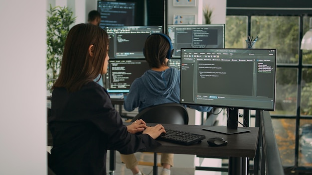 Programista baz danych wykorzystujący komputer do pisania kodu w oknie terminala, tworzący nowy interfejs sieciowy przy biurku. Algorytm pracy kodera i parsowania systemu w biurze agencji oprogramowania, serwer IT.