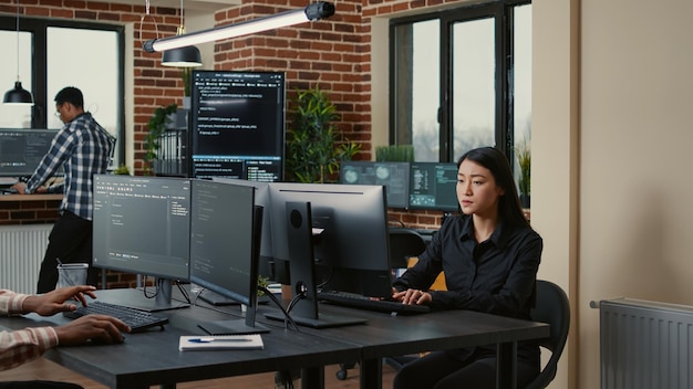Programista ze schowkiem siedzi przy biurku przed programistą piszącym kod, podczas gdy zespół administratorów baz danych oblicza big data. Zespół mieszanych programistów pracujących nad oprogramowaniem do uczenia maszynowego.