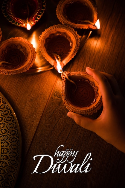 Zdjęcie projekt kartki z życzeniami happy diwali przy użyciu lamp olejnych beautiful lit diya or clay