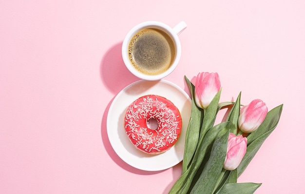 Projekt karty z pozdrowieniami z 8 marca z filiżanką kawy i spodkiem z pączkiem tworzącym cyfrę osiem i delikatnym różowym tulipanem w pobliżu