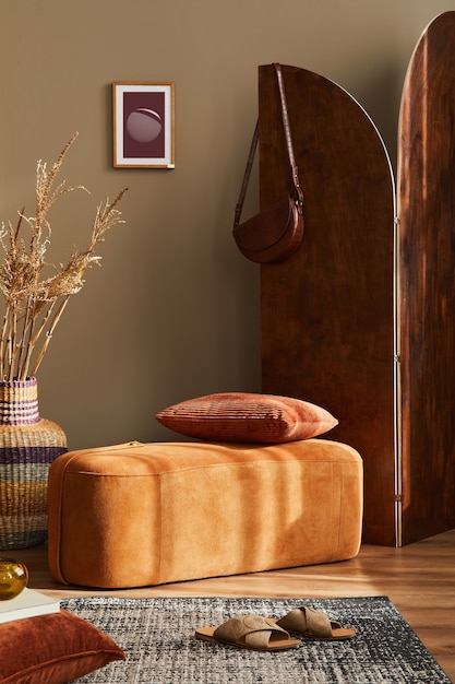 Projekt wnętrza pokoju domowego ze stylową pufą dywan ramka na zdjęcia poduszka koc rattanowy kosz suszony kwiat drewniany parawan i eleganckie akcesoria osobiste w nowoczesnym wystroju domu
