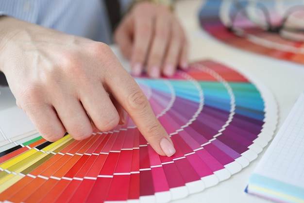 Projektant trzymając próbkę koloru na biurku w biurze zbliżenie. Koncepcja wnętrza