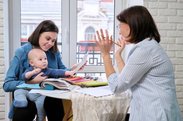 Projektantka Wnętrz I Klientka Z Dzieckiem Wybierająca Tkaniny I Materiały.