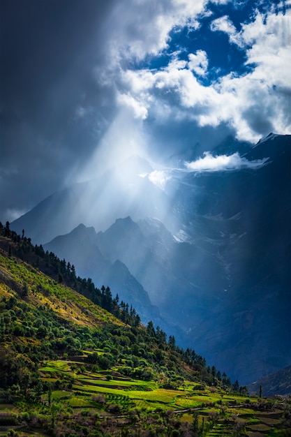 Promienie słoneczne przez chmury w dolinie Himalajów w Himalajach