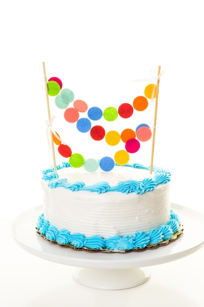 Prosty biały tort urodzinowy z girlandą tortową.