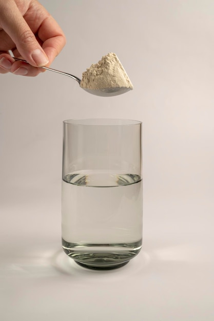 Proszek białkowy i łyżka ze szklanką wody Suplementy diety