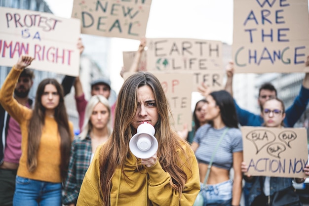 Protesty dotyczące zbliżenia młodej dziewczyny z pokolenia Z z megafonem w dłoni i surowym i zdecydowanym wyrazem twarzy