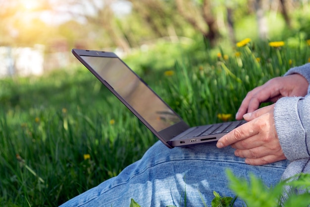 Prowadzenie biznesu na świeżym powietrzu wśród natury Zbliżenie dłoni kobiety z laptopem
