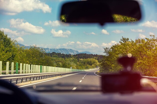 Prowadzenie samochodu na autostradzie w słoneczny dzień Widok z samochodu górskiego krajobrazu wiosną Alpy Włochy Europa