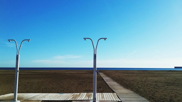 Prysznice na plaży przy promenadzie na tle niebieskiego nieba