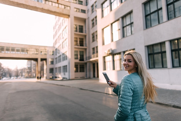 Przechodzień rozmawia przez telefon w mieście na ulicy. Nowoczesna telekomunikacja, technologia social media