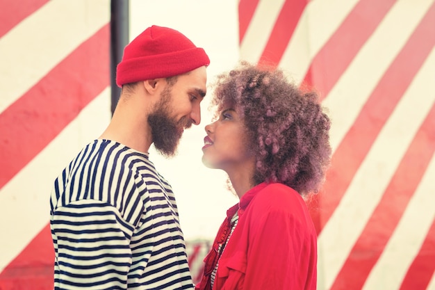 Zdjęcie przed całowaniem. romantyczni atrakcyjni młodzi ludzie uprzejmie uśmiechają się i stoją blisko siebie