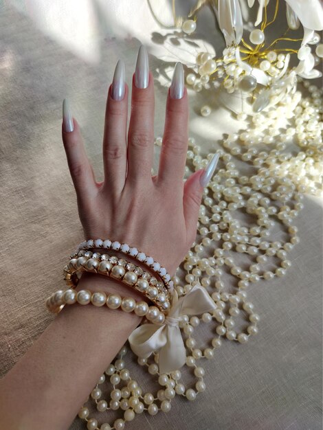 Zdjęcie przedłużanie paznokci z wzorem z kryształkami i perłowymi pocieraniami z bliska