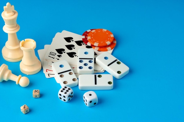 Przedmioty do gry w szachy, poker i domino na niebieskim tle, zdjęcie studyjne