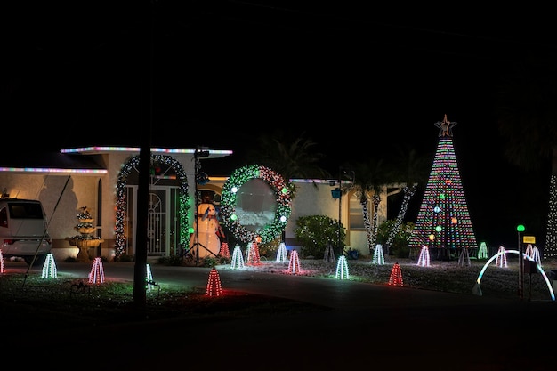 Przedni dziedziniec z jasno oświetlonymi dekoracjami świątecznymi Zewnętrzny wystrój domu rodzinnego na Florydzie na ferie zimowe
