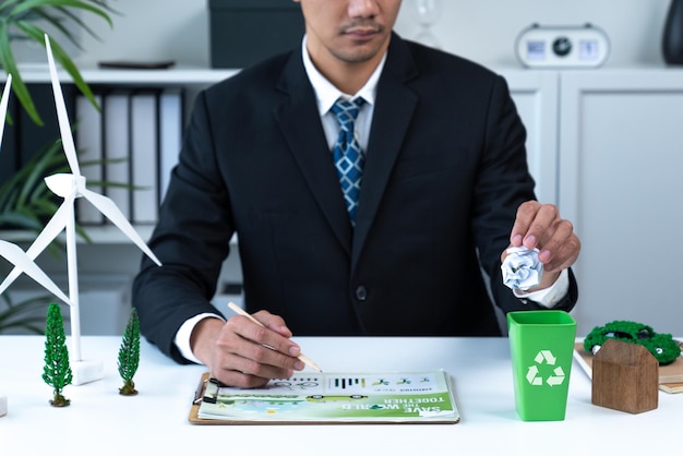 Przedsiębiorca umieścił odpady papierowe w małym koszu do recyklingu w swoim biurze Gyre