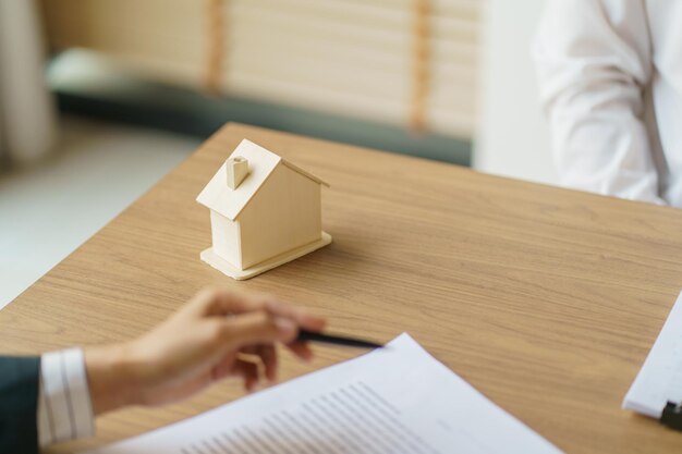 Przedsiębiorcy podpisujący umowę zawieranie umowy z agentem nieruchomości Koncepcja konsultanta ubezpieczenia domowego xAR inwestycja nieruchomości ubezpieczenie nieruchomości bezpieczeństwo agent nieruchomości oferuje dom