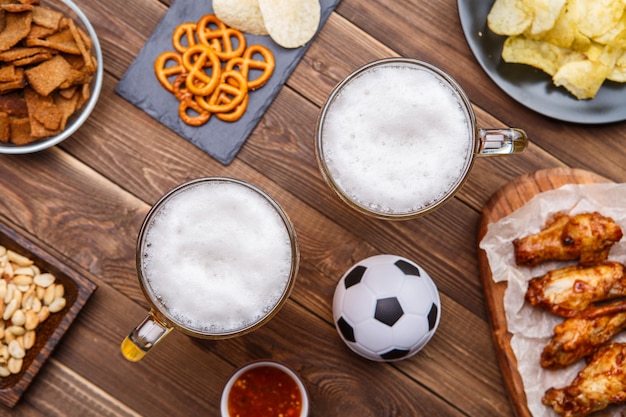 Przekąski i piwo na stole na imprezę piłkarską i oglądanie meczu piłki nożnej.