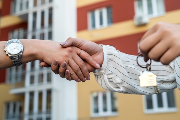 Zdjęcie przekazanie kluczy do domu między pośrednikiem a nowym właścicielem. koncepcja sprzedaży
