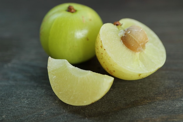 Przekrój świeżej Jagody Amla Z Całymi Owocami Na Czarnym Drewnianym Tle