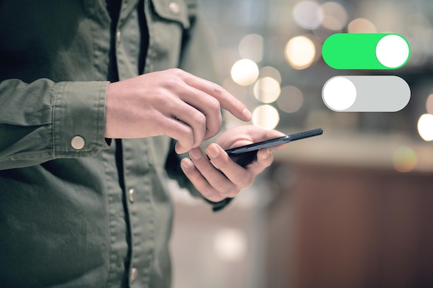 Przełącznik mobilny szaro-zielony Mężczyzna trzymający telefon w dłoni