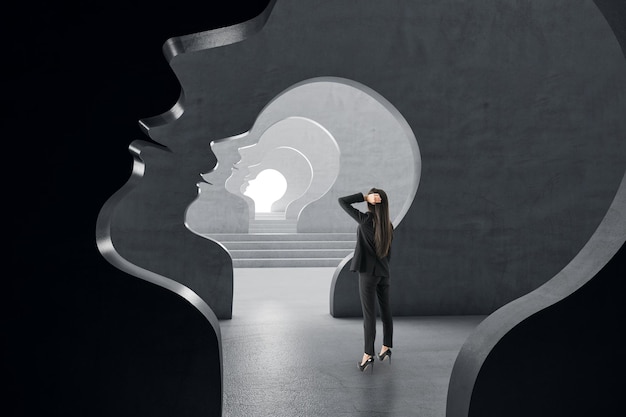 Zdjęcie przemyślana młoda europejska kobieta biznesu stojąca wewnątrz abstrakcyjnego tunelu zarys ludzkiej głowy