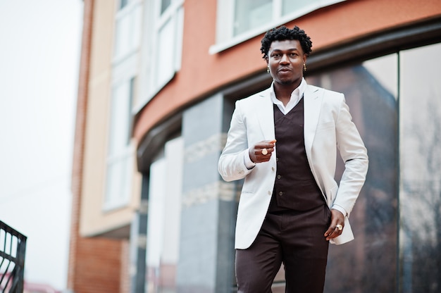 Przemyślany młody przystojny mężczyzna Afroamerykanów w formalnej odzieży. Czarny stylowy model mężczyzna w białej kurtce.