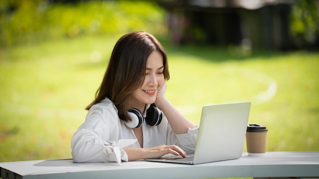 Przemyślany Uśmiech Szczęśliwa Kobieta Rozmawiająca Online Lub Spotykająca Się Online Pracująca Z Laptopem W Parku