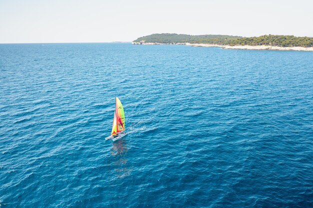 Przenośna żaglówka katamaran windsurfingowy w błękitnej wodzie Adriatyku