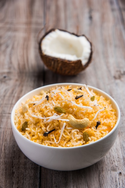 Przepis na słodki ryż kokosowy znany również jako narali bhat wykonany z szafranu, orzechów nerkowca, goździków i podawany w białej misce. Popularne jedzenie konkani lub maharasztra.