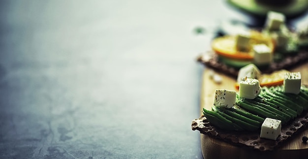 Przepisy kulinarne z awokado. Dojrzałe, zielone awokado na drewnianej desce do krojenia do serwowania.