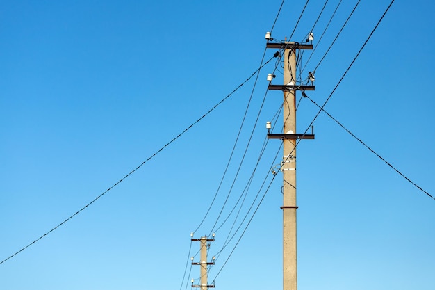 Przeplatanie przewodów elektrycznych ze światłami na tle nieba. Sylwetka filaru