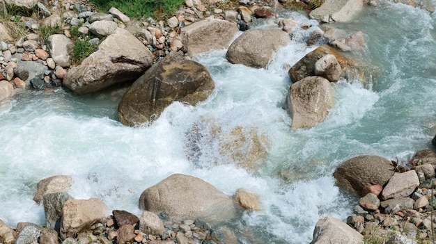 Przepływ górskiej rzeki z rozpryskami i falami z bliska