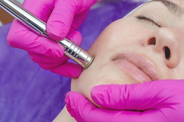 Przeprowadzanie zabiegu RF Lifting w salonie kosmetycznym Twarz kobiety oczyszczająca skórę owalna twarz