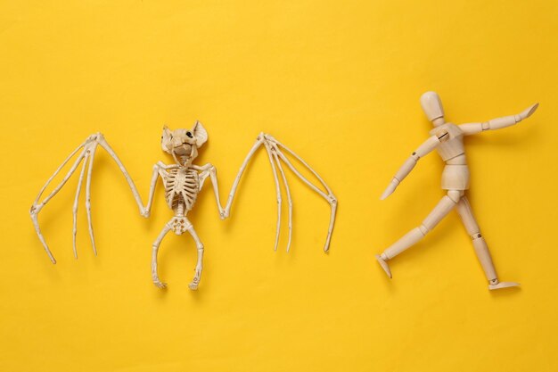 Przerażający szkielet nietoperza i biegnąca kukiełka na żółtym tle Układ Halloween