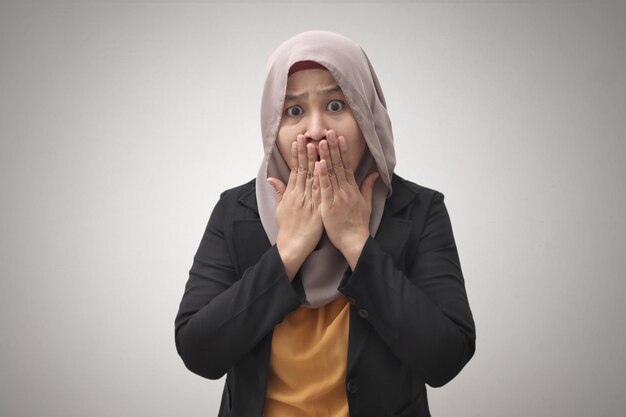 Zdjęcie przerażona muzułmańska bizneswoman milcząca wstrząśnięta młoda azjatka zakrywająca usta rękami