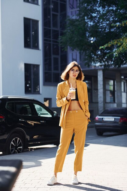 Przerwa na kawę Młoda modna kobieta w bordowym płaszczu w ciągu dnia ze swoim samochodem