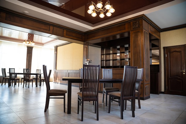 Przestronne wnętrze nowoczesnej pustej dużej restauracji ze stołami i krzesłami