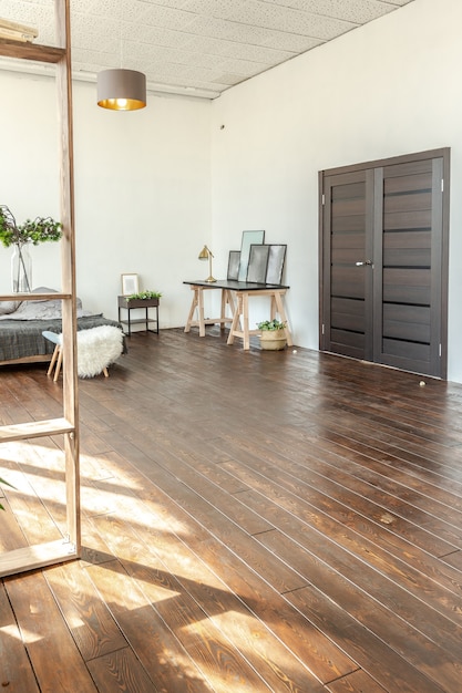 Przestronny apartament typu studio urządzony w drewnie i bieli. Minimalistyczny design z ogromnymi oknami w słońcu. kuchnia i salon