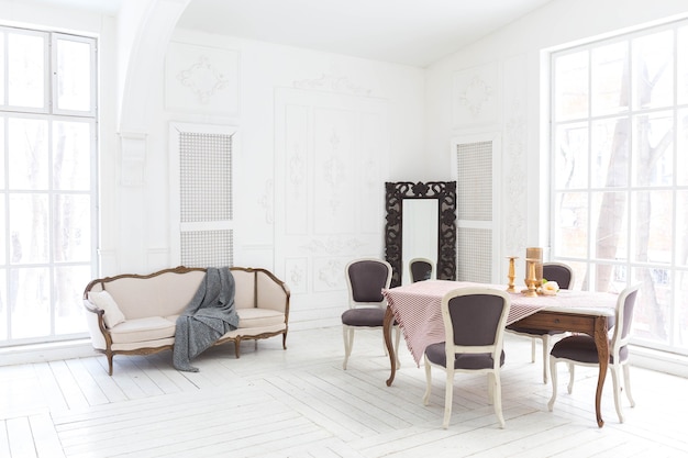 Przestronny jasny salon o stylowym klasycznym wystroju z antycznym wystrojem i pięknymi eleganckimi meblami w starym stylu