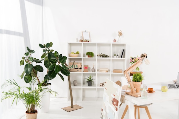 Przestrzeń robocza z zielonymi roślinami i biurkiem w nowoczesnym biurze