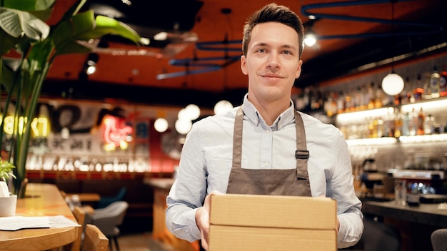 Przesyłkę kurierską odbiera pracownik restauracji Wysyłając pizzę w paczce