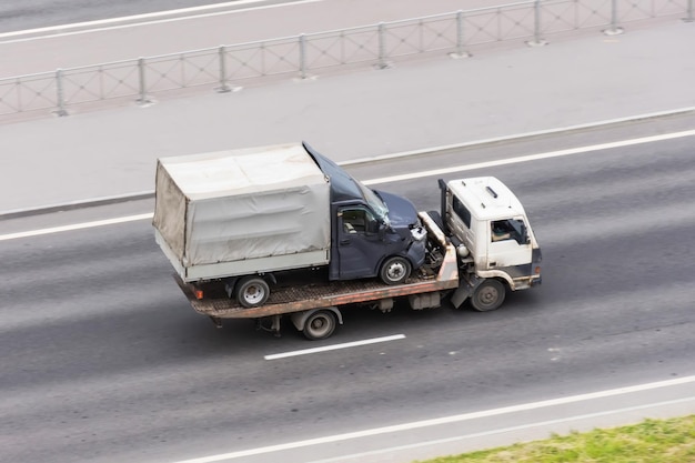 Przewoźnik ciężarówek z rozbitą ciężarówką po wypadku z wgniecioną maską na asfaltowej drodze