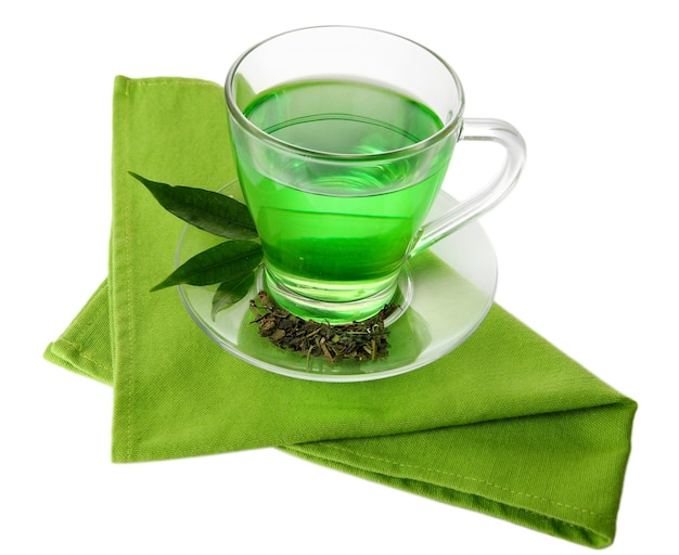 Przezroczysta filiżanka zielonej herbaty na serwetce odizolowywającej na bielu
